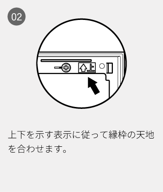02 上下を示す表示に従って縁枠の天地を合わせます。